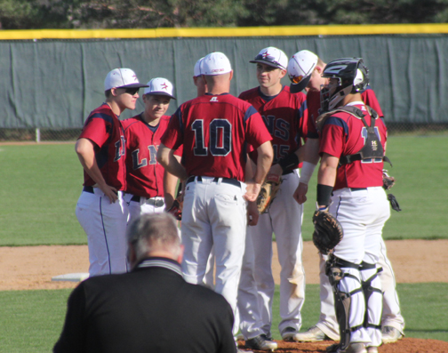 Coach Lanny Bolles meets with his infielders on the pitchers mound during the Gators game against the Spartans on April 13.