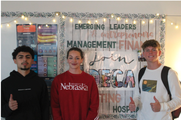 Mateen Younis, Ms. Smith, and Ben Rorabaugh pose in DECA classroom. 