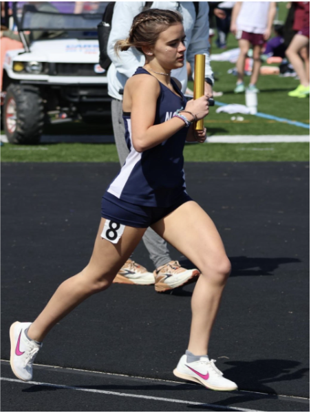 During an impressive track season, Addi Brooks (11) runs a relay event during a past track meet. She went on to pass her baton quickly and smoothly, aiding in a victory for the LNS Gators.