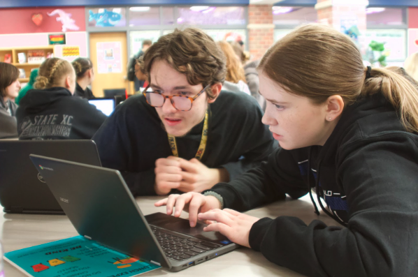 Bristol Urwin (10) and a fellow Unified council member are creating a sticker to be produced by their advisor. By the end of their meeting,  their design included a gator and the Lincoln North Star colors, Navy and Maroon. 